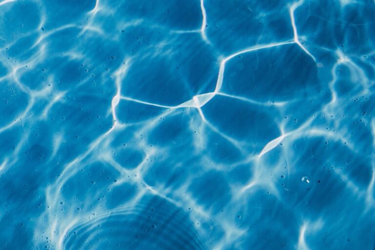 Clear pool water with sun reflections